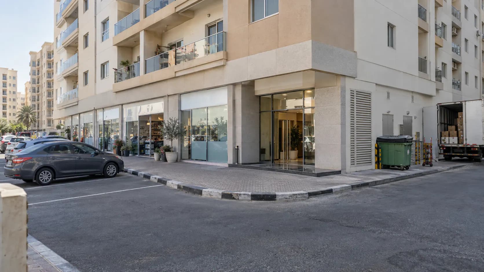 Sharjah mixed-use building with homes, shops, parking, and a service entrance